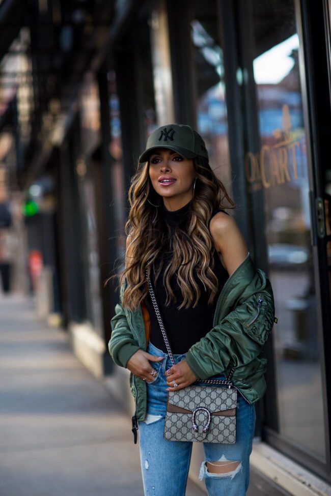 fashion blogger mia mia mine wearing an alpha industries bomber jacket and a gucci mini dionysus bag