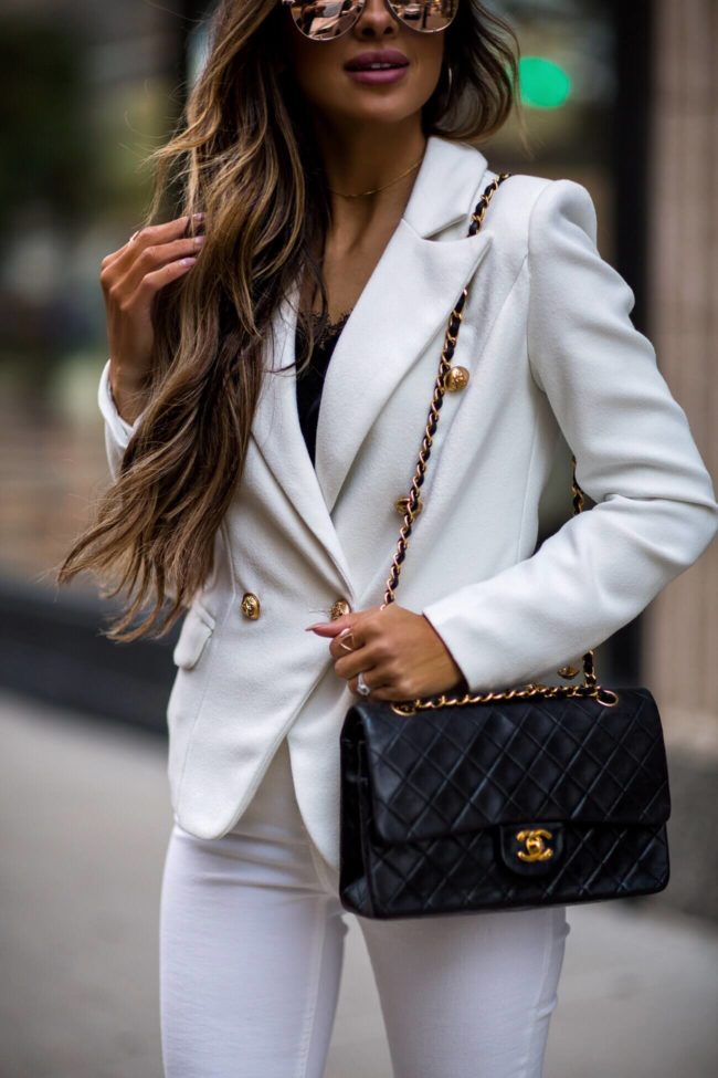 fashion blogger mia mia mine wearing a white lioness blazer and a chanel bag