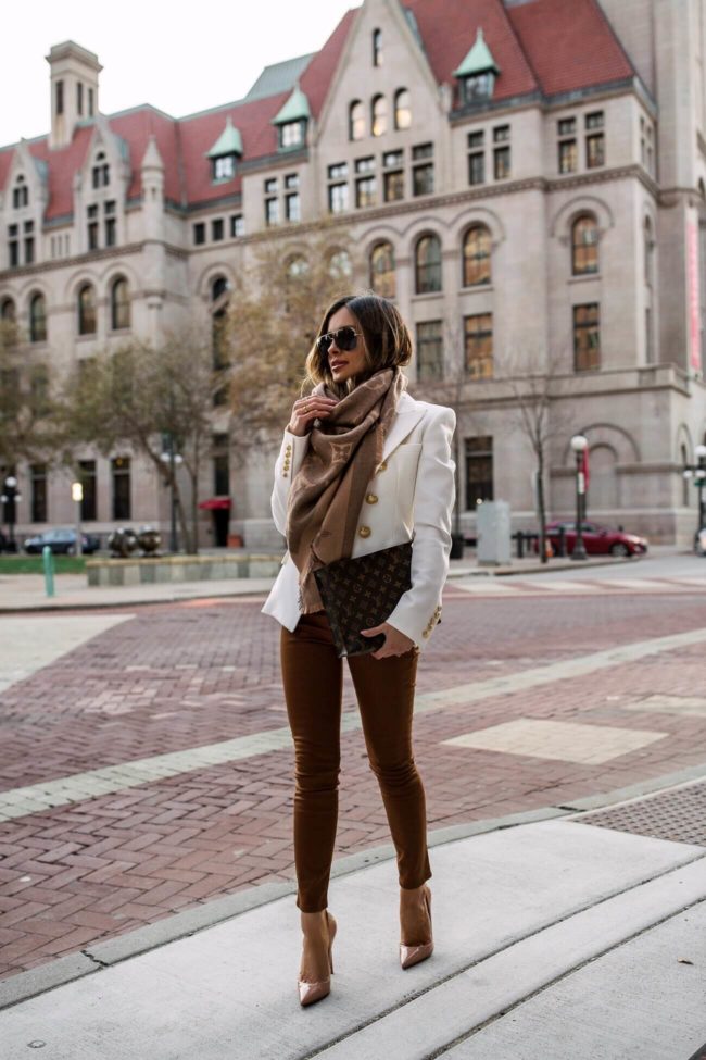 fashion blogger mia mia mine wearing a white balmain blazer and a louis vuitton pouch 26 