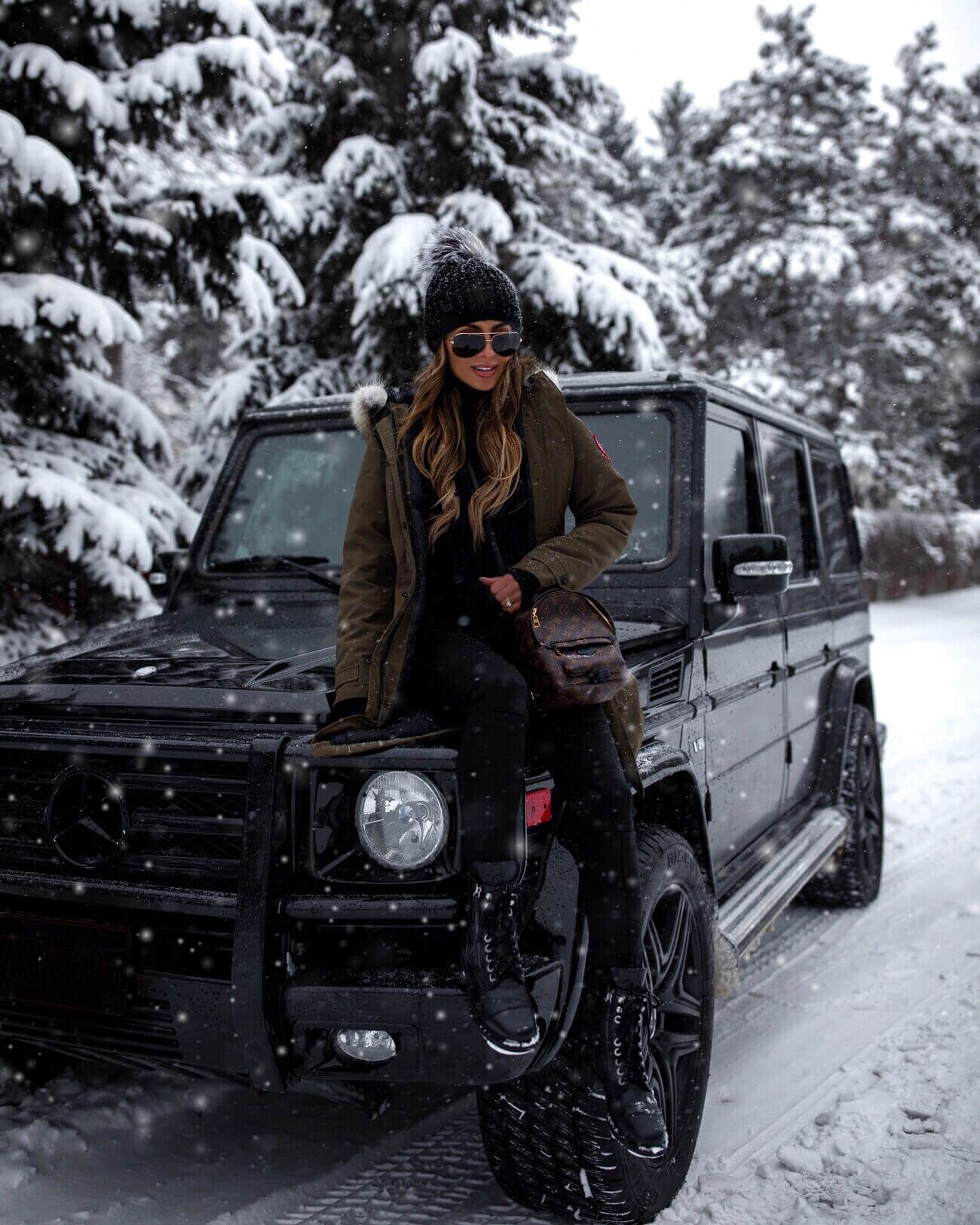 fashion blogger wearing a canada goose parka and a louis vuitton palm springs mini backpack