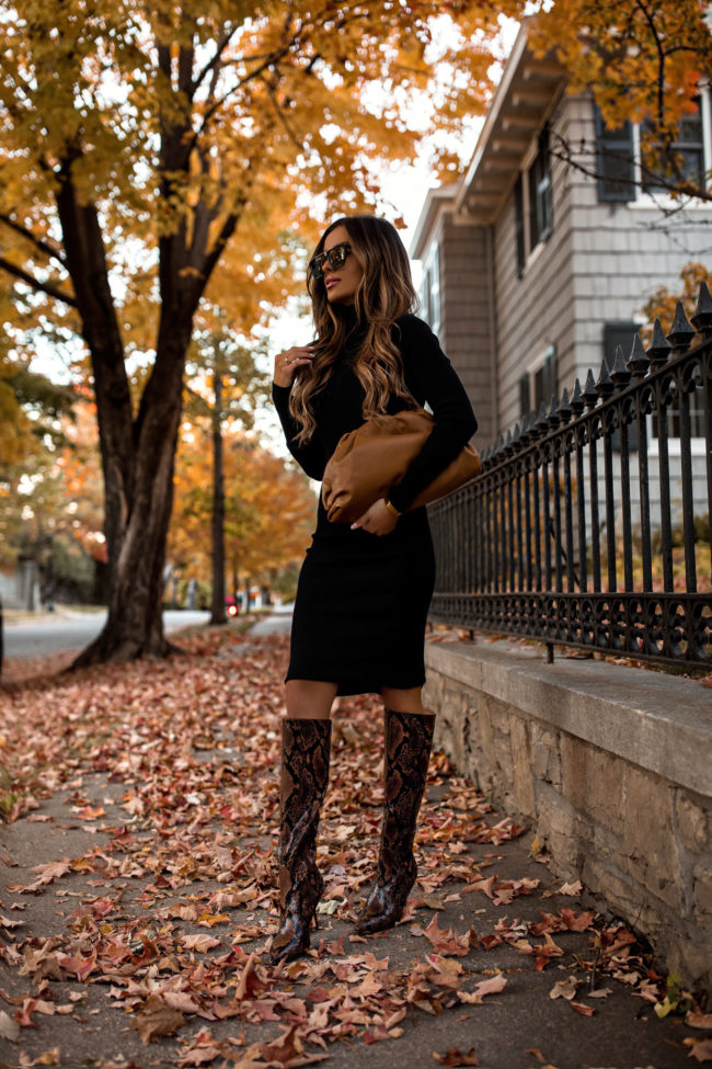 fashion blogger mia mia mine wearing a black sweater dress and snakeskin boots from Express