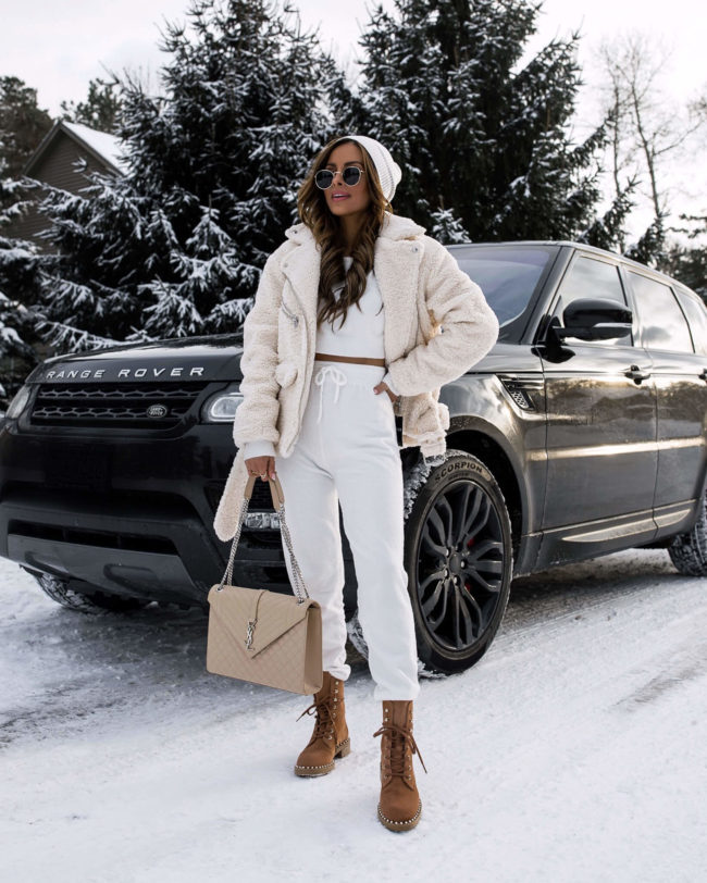 fashion blogger mia mia mine wearing a white loungewear set and a shearling moto jacket