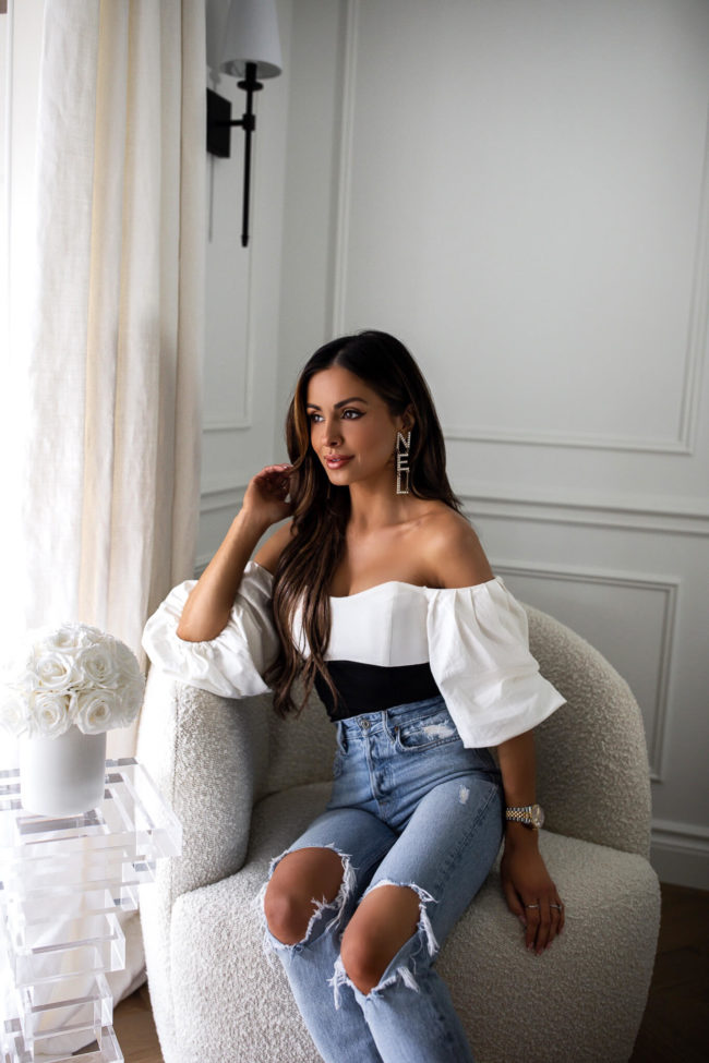 fashion blogger mia mia mine wearing a white off-the-shoulder bodysuit from nordstrom with chanel earrings