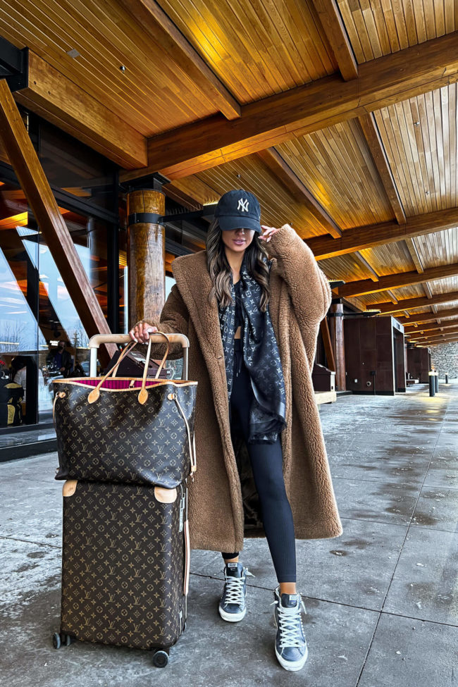 fashion blogger wearing a max mara teddy bear at the airport