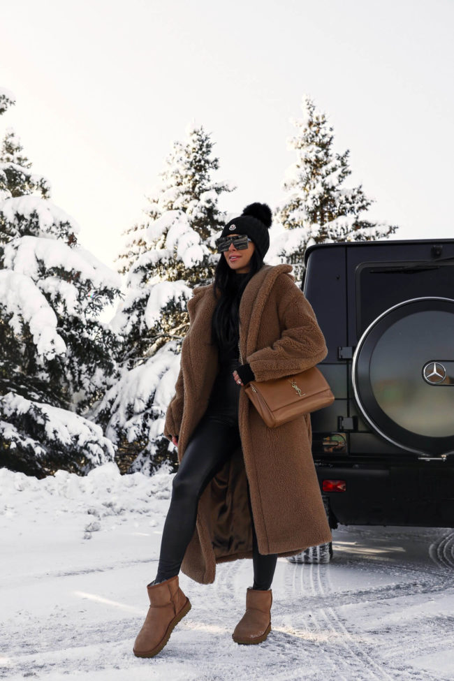 fashion blogger wearing a camel teddy bear coat and black faux leather leggings