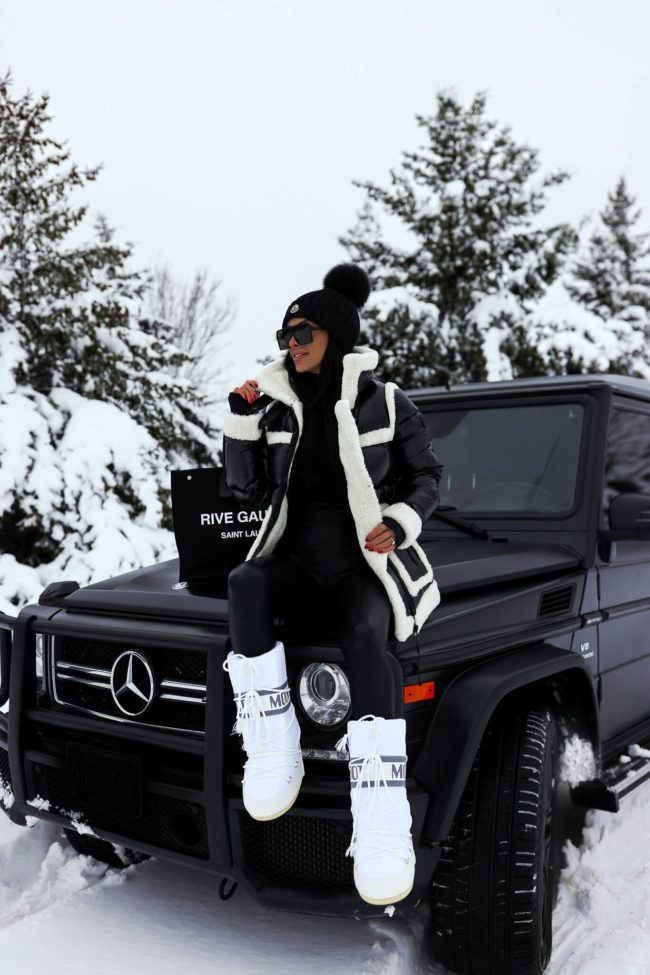 fashion blogger wearing a black shearling puffer jacket from saks and moon boots