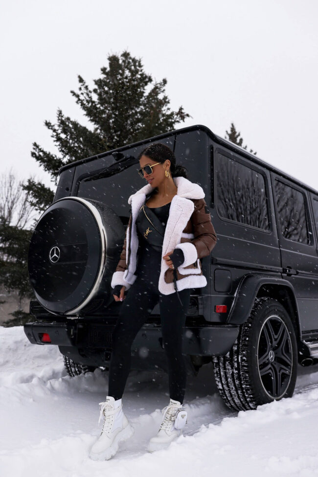 fashion blogger mia mia mine wearing a brown shearling puffer jacket and white prada combat boots