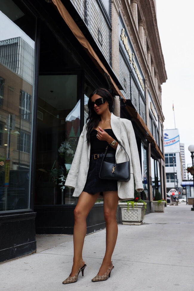 fashion blogger wearing a denim skirt with a saint laurent logo belt